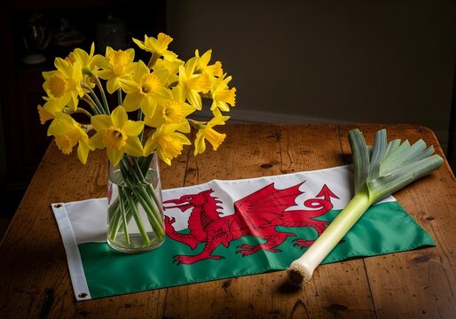 Celebrating St. Davids Day - Daffodils, Welsh Flag, and Leek on Table.