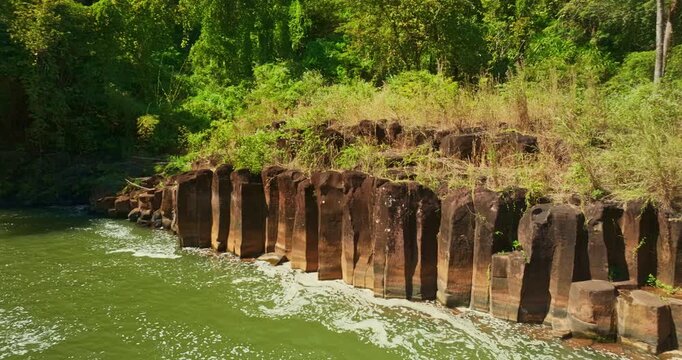 Beautiful drone view of Tad Pha Suam Waterfall in Southern Laos. A stream cascades over unusual rock terraces resembling a bridal chamber forming a striking natural attraction near Pakse in Champasak