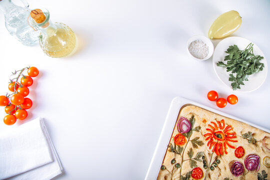 Floral focaccia with herbs, tomato and olive oil flat lay