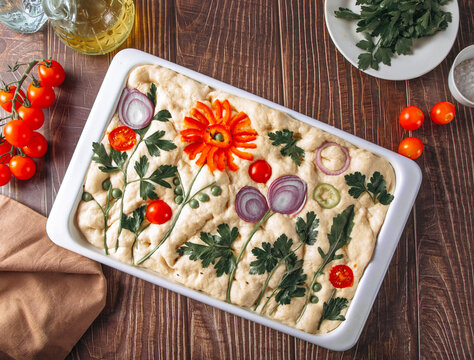 Floral focaccia bread with vegetable art ready to bake