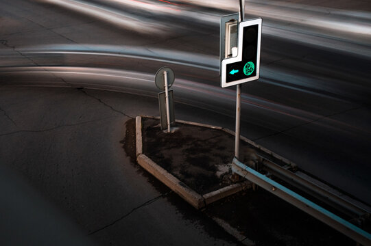 Night traffic blur around green light at urban intersection