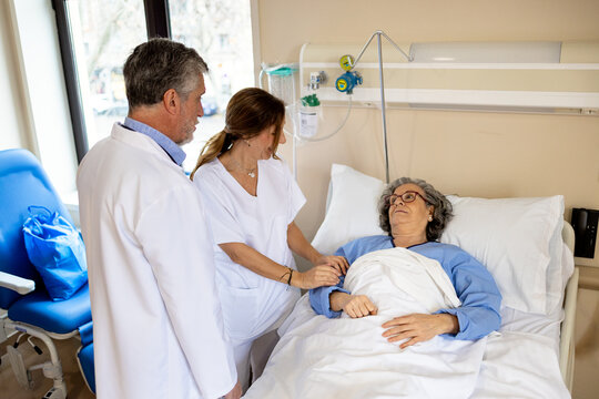 Doctors attending to patient in hospital room
