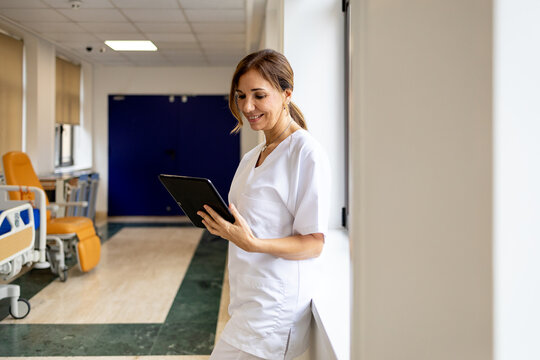 Nurse using digital tablet in hospital corridor