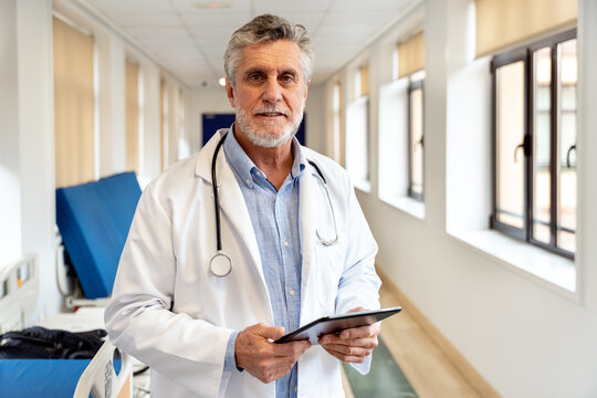 Doctor using digital tablet in hospital hallway