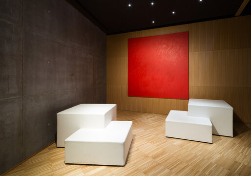 Minimalist art space with red accent wall and seating