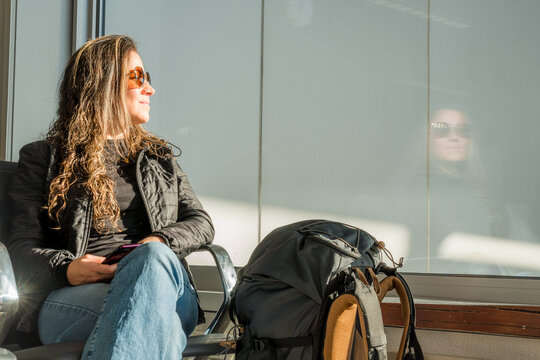 Woman in airport waiting area with reflection