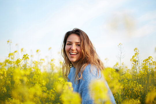 Portrait of woman in flower field surrounded by nature