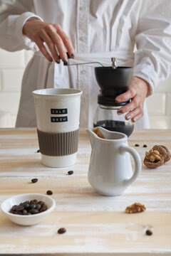 Close-up of hands using French press for fresh coffee