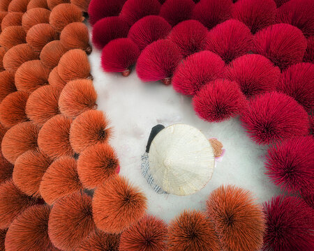Worker amidst vibrant incense sticks in concentric circles