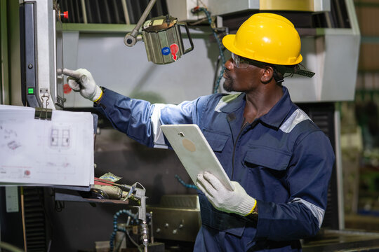 Industrial technician inspecting machinery in manufacturing facility technical process indoor environment action-oriented viewpoint