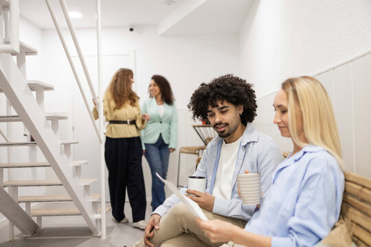 Coworking team discussing documents in modern office lounge