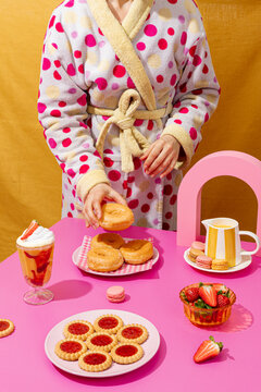 Breakfast treats with donuts and cookies on pink table