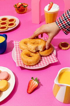Assorted pastries and drinks on vibrant pink background