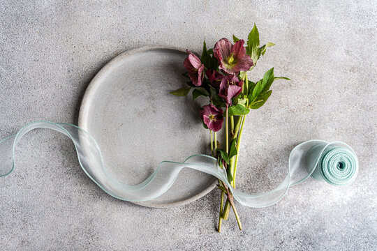 Minimal spring hellebore bouquet with ribbon on stone