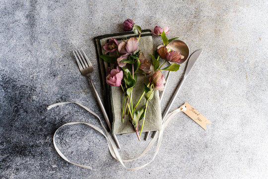 Spring hellebore floral table setting with rustic cutlery