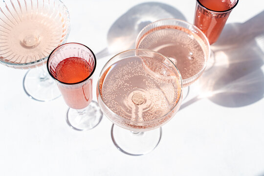 Sparkling rose wine in elegant glasses casting shadows