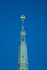 Obraz premium Church tower spire with cross against clear blue sky