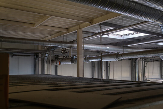 Industrial ventilation system with metal air ducts and pipes inside factory building