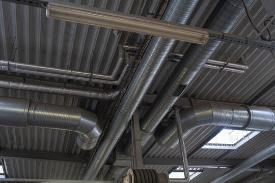 Industrial ventilation system with metal air ducts and pipes inside factory building