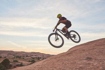 Obraz premium Nature, man and extreme sport with jump on mountain bike for action stunt, adventure and space. Energy, bicycle and person with air trick on rocky terrain for adrenaline, skill performance and hobby