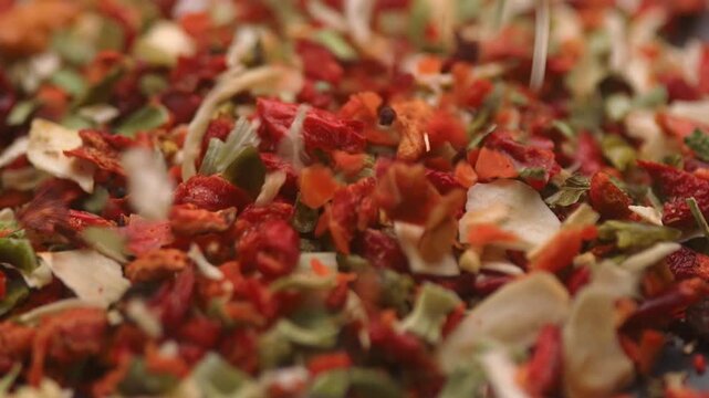 chopped dry dried tomatoes, chili and other spices falling on table