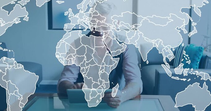 Senior man tapping tablet and causing animated world map overlay, visualizing tech data in lounge