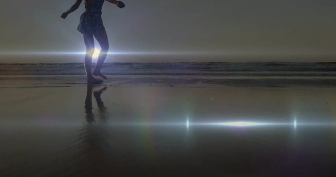 Woman stepping on wet sand causing reflection and flare, pausing arms out balancing shell for ads