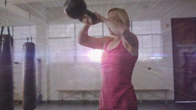 Vertical video: Starting woman pink top training driving hips swinging kettlebell at gym flare
