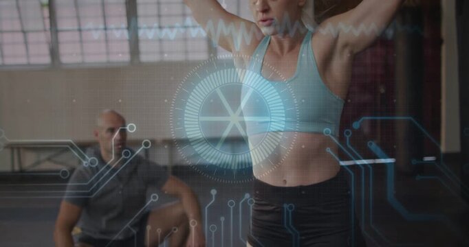 Vertical video: Driving woman in blue bra from squat lifting bar coach spotting for form HUD at gym