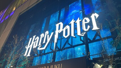 Fototapeta premium Harry Potter promotional display with an illuminated logo and magical theme at the Zara Harajuku-ten store facade in Shibuya - Tokyo, Japan, December 13, 2025