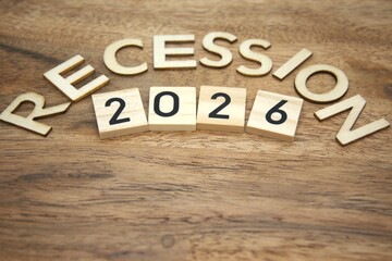 Fototapeta premium Recession 2026 text made from wooden letters representing economic forecast and financial crisis. Concept of future uncertainty and planning under economic pressure.