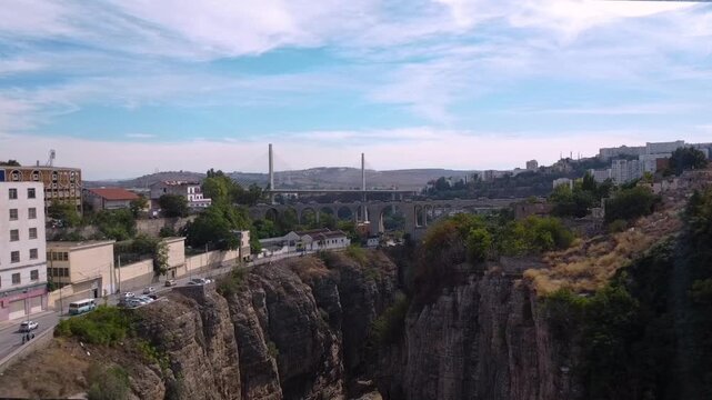 Scenic aerial view of the historic Sidi Rached Viaduct and the modern Salah Bey Bridge spanning the deep Rhumel River gorge in Constantine, Algeria.