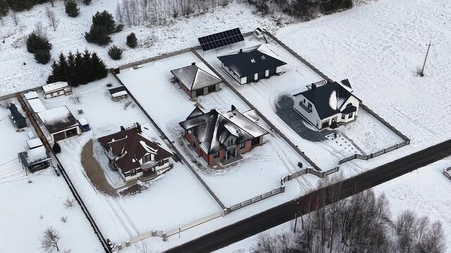 Aerial winter neighborhood showing roof snow melting differences