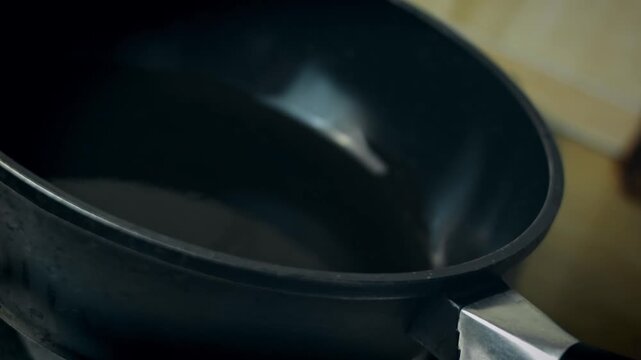 Cauldron tilted to spread oil evenly across surface, close up