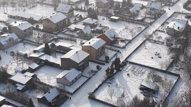 Snow covered suburb roofs showing home insulation differences
