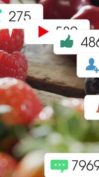 Vertical video: Berries shifting on wood, sliding notification bar spawning social likes bubbles