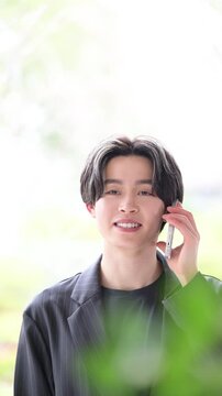 電話対応をする若い男性ビジネスマンの信頼感ある営業や連絡の相談などの顧客対応、サポートの上半身のビジネスシーンのコミュニケーションの縦動画