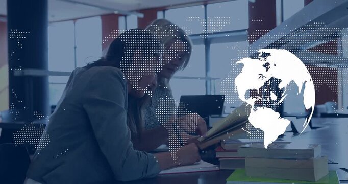 Right woman pointing at book, guiding left writing notes for study as globe overlay obscuring right