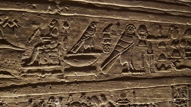 Hieroglyphs and images of Egyptian gods at the Ancient Egyptian Temple of Edfu. Edfu is the site of a Ptolemaic-era Temple of Horus and an ancient settlement in Egypt.