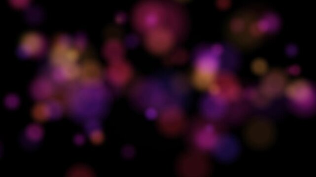 Abstract motion video clip showing dynamic bokeh light particle effects with shimmering blurred spots and vibrant color transitions against a black background