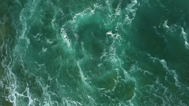 Drone top dow, swirling motion into the water with beautiful colours and patterns in the water.