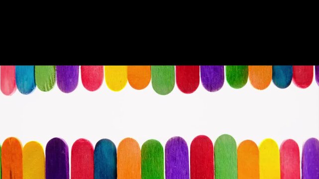 Colorful rainbow wooden popsicles in motion