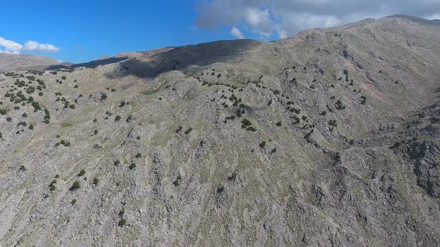 Aerial drone flight over rocky slopes of the Ethiopian Highlands near Simien Mountains peaks. Skyborne ascent above stony Abyssinian uplands around Ras Dashen summits and sparse trees.