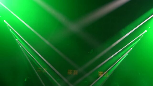 Bright green spotlights cut through the dark atmosphere of an empty stage or venue. The dynamic beams create circular patterns on the floor, evoking an energetic mood for a concert or live event.
