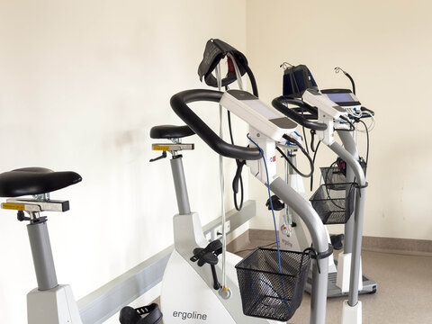 Klagenfurt, Austria - March 25, 2026: Ergoline stationary exercise bikes positioned in a rehabilitation center with a neutral wall and floor visible in the background