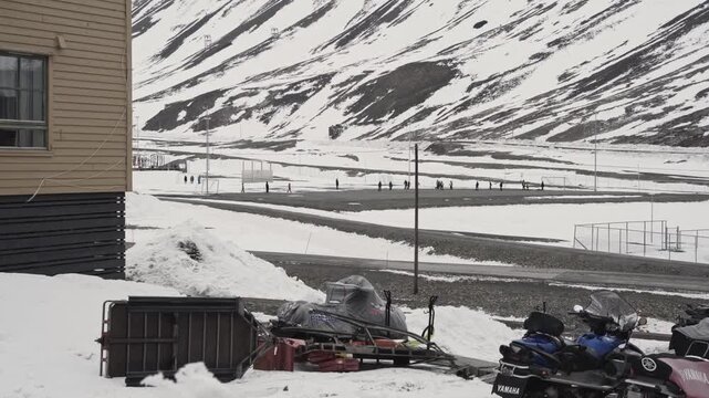 Snowy landscape with mountains and people walking along the road, longyearbyen, svalbard in norway