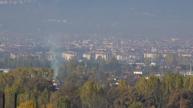 Panoramic view of Bolu Turkey city center amid autumn haze, sunny skyline and urban landscape. Sweeping vista across Anatolian town district veiled by smoky mist, foliage, hills, bright daylight.