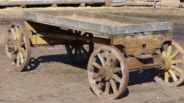Rustic old wooden wagon sitting on a dirt field, perfect for country or rural themed designs