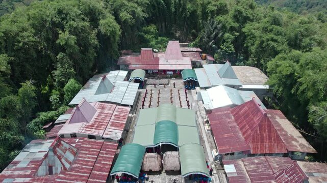 High angle drone footage of local people performing the traditional Reba dance in a circle within a tribal village in Bajawa, East Nusa Tenggara.
