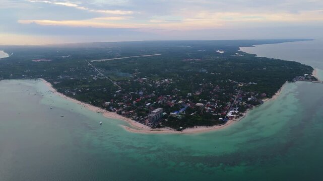 Cinematic drone panorama of the lush tropical coastline of Bantayan Island in Cebu, Philippines, featuring clear turquoise waters